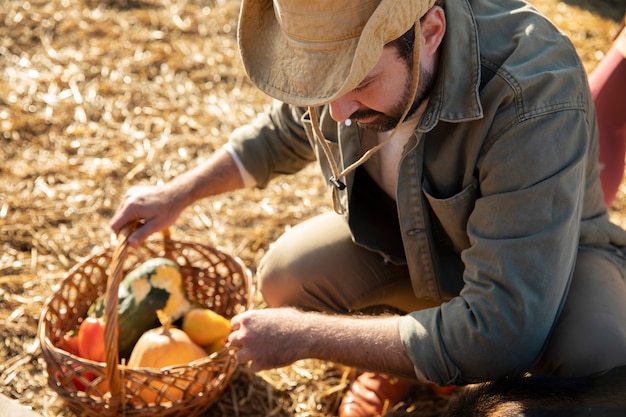 Joven agricultor sosteniendo una canasta con verduras de su granja