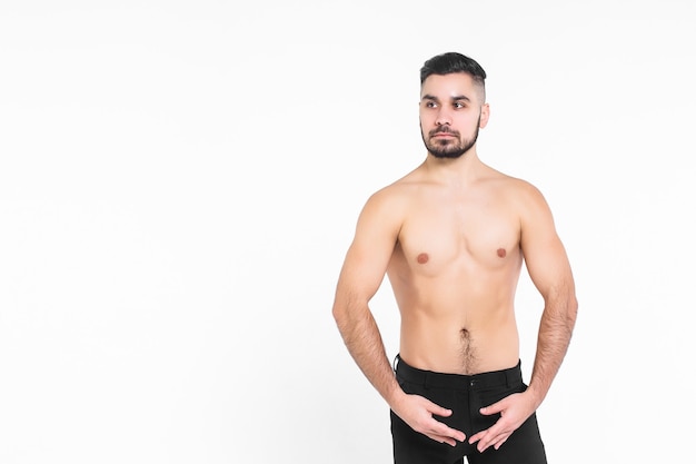 Joven aislado en la pared blanca, vestido con pantalones negros con el torso desnudo