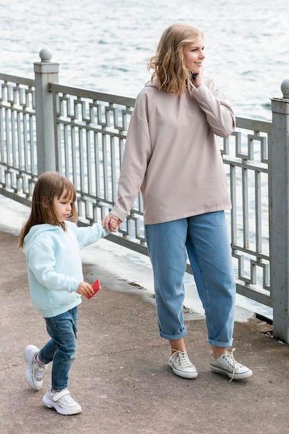 Foto gratuita joven al aire libre y mamá junto al mar