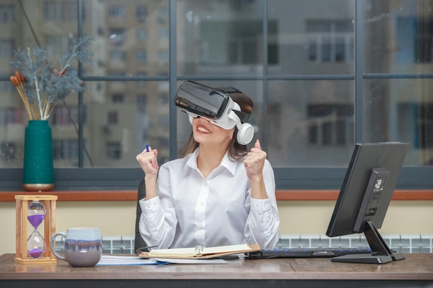 Una joven alegre con gafas VR y aprieta el puño