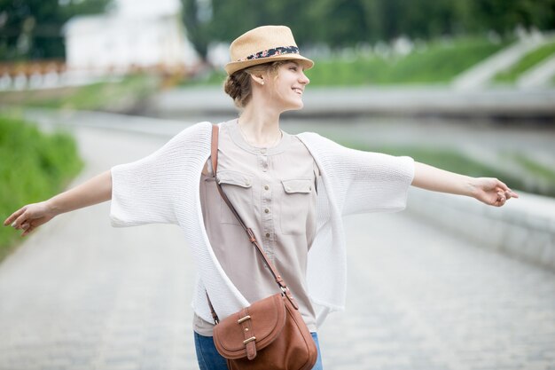 Joven alegre mujer feliz viajero en sombrero de paja disfrutando de su viaje