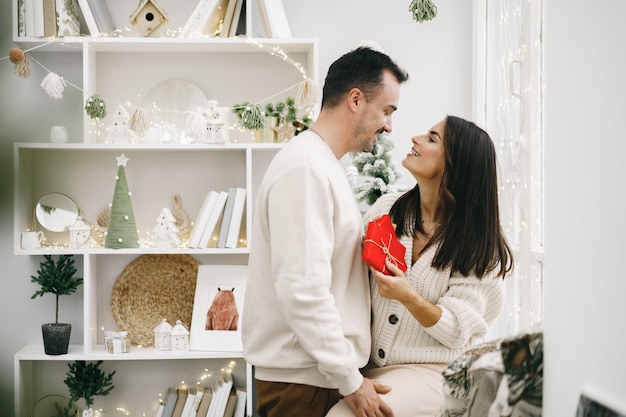 Joven alegre pareja enamorada de presente para navidad