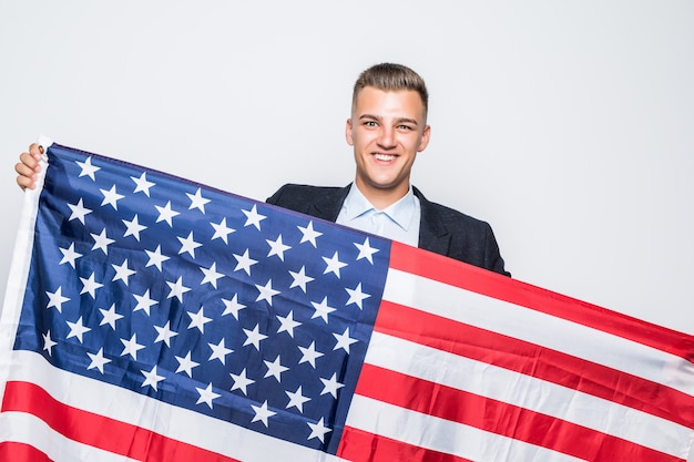 Joven alegre sosteniendo la bandera de Estados Unidos gris