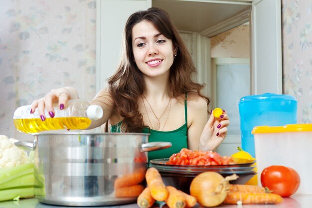 joven ama de casa cocinar con aceite