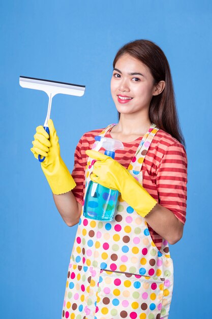 Joven ama de casa femenina con productos de limpieza