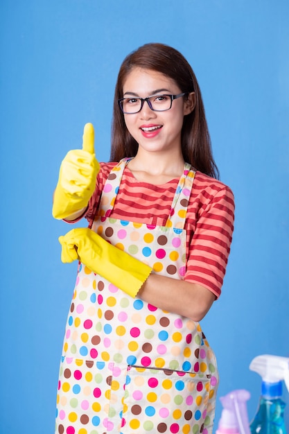 Joven ama de casa femenina con productos de limpieza