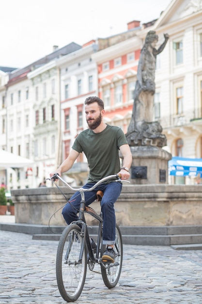 Joven andar en bicicleta delante de la estatua