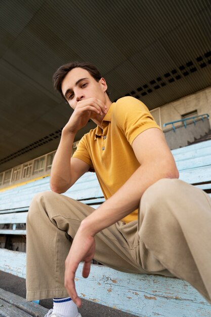 Joven de ángulo bajo posando al aire libre