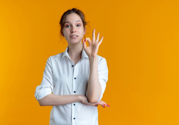 Joven ansiosa rubia rusa gestos ok signo de mano