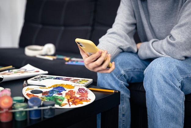 Una joven aprende a dibujar usando un video en un teléfono inteligente