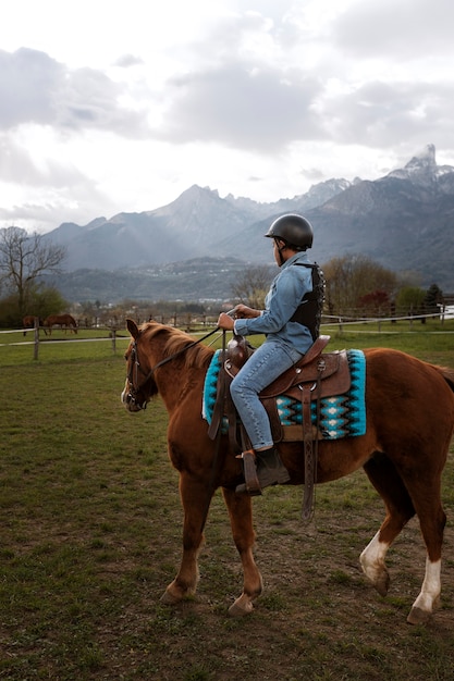 Foto gratuita joven aprendiendo a montar a caballo