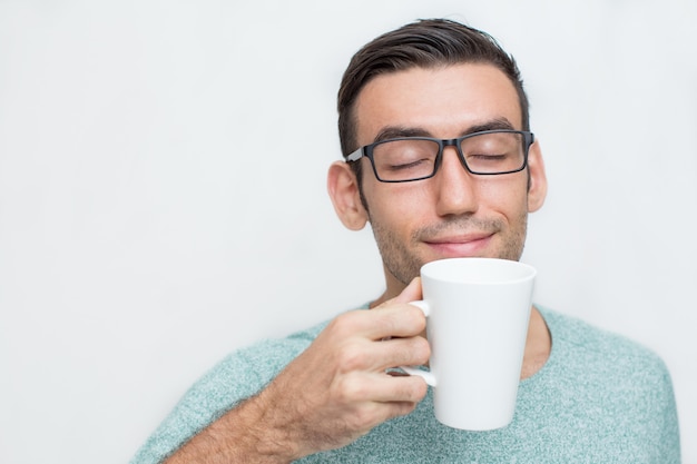 Foto gratuita joven apuesto disfrutando de olor de té