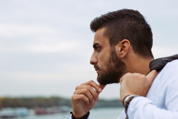 Joven apuesto hombre mirando la vista de la ciudad