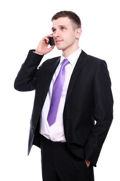 Joven y apuesto hombre de negocios usando teléfono celular