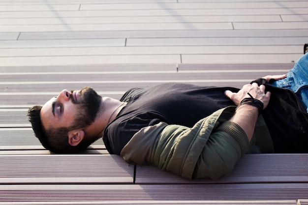 Foto gratuita joven apuesto hombre por la que se en las escaleras, relajante