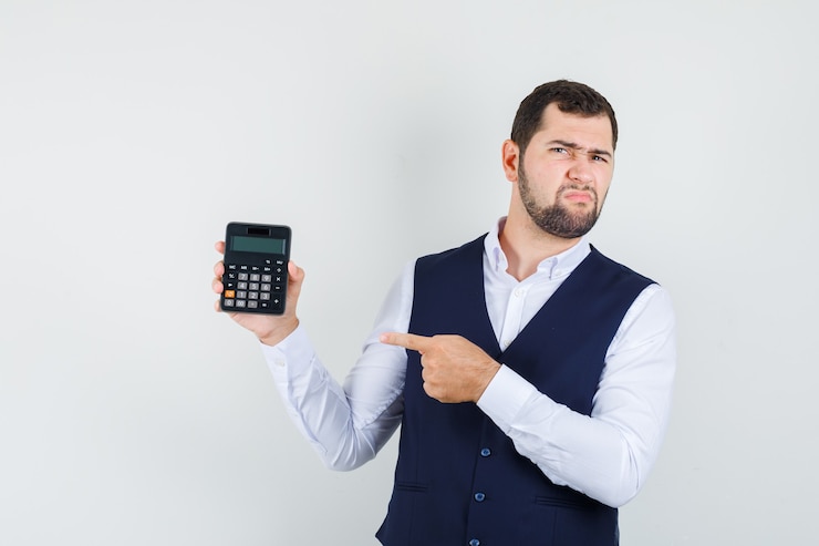 Foto gratuito joven apuntando a la calculadora en camisa, chaleco y mirando disgustado