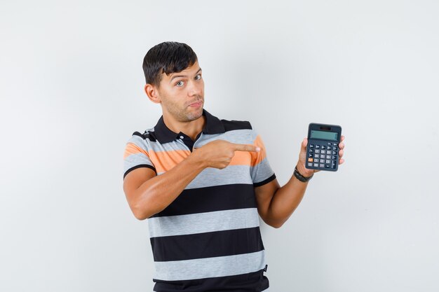 Joven apuntando a la calculadora en camiseta