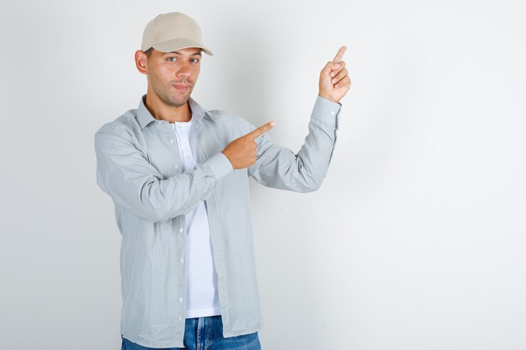 Foto gratuito joven apuntando con el dedo a algo en camiseta con gorra