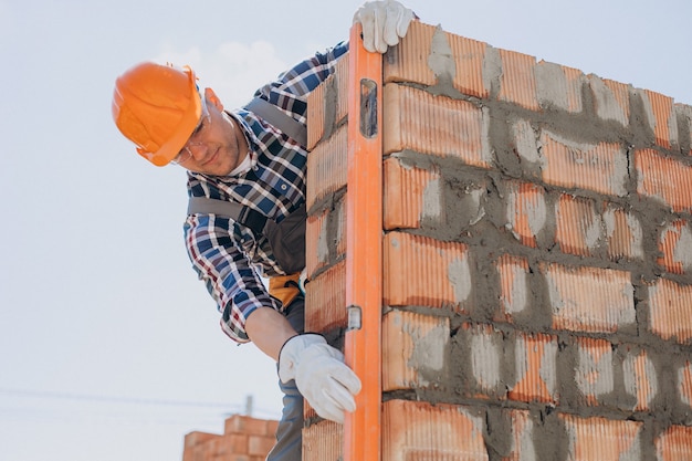 Joven artesano construyendo una casa