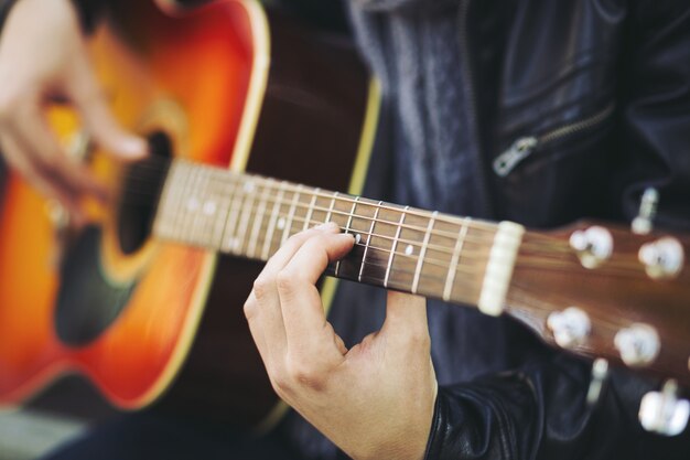 Joven artista callejero atractivo con su guitarra