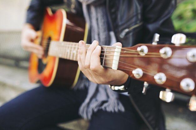 Joven artista callejero atractivo con su guitarra