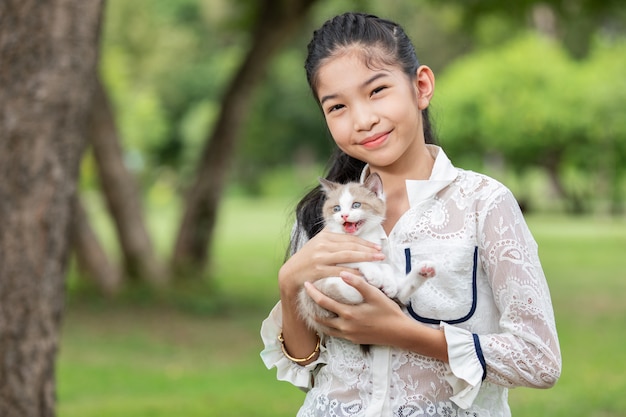 Joven asiática con gatitos en el parque
