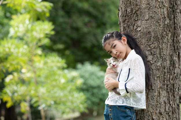 Joven asiática con gatitos en el parque