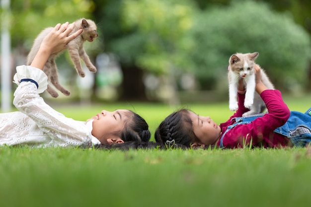 Joven asiática con gatitos en el parque