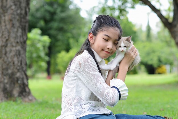 Joven asiática con gatitos en el parque