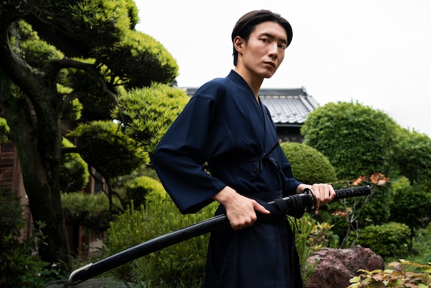 Joven asiático con espada samurai