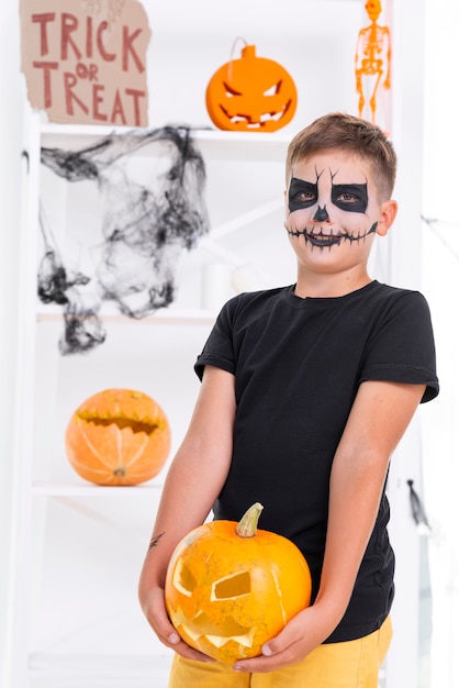 Joven aterrador con calabaza de halloween