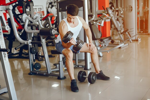 Un joven y atlético se dedica a los deportes en el gimnasio