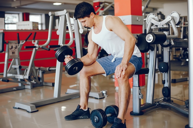 Un joven y atlético se dedica a los deportes en el gimnasio