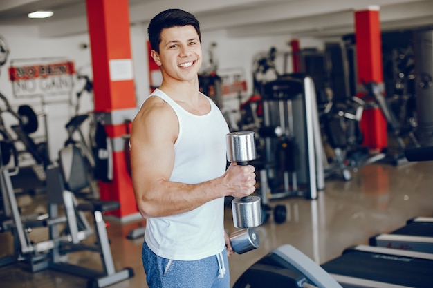 Un joven y atlético se dedica a los deportes en el gimnasio