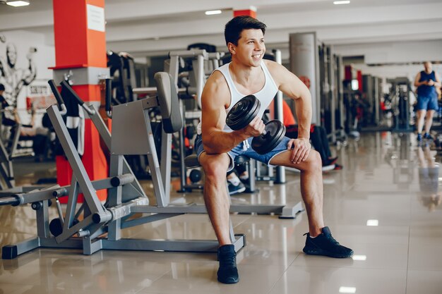 Un joven y atlético se dedica a los deportes en el gimnasio