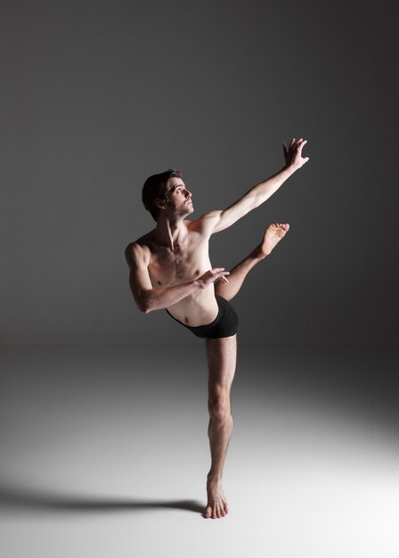 La joven y atractiva bailarina de ballet moderno en la pared blanca