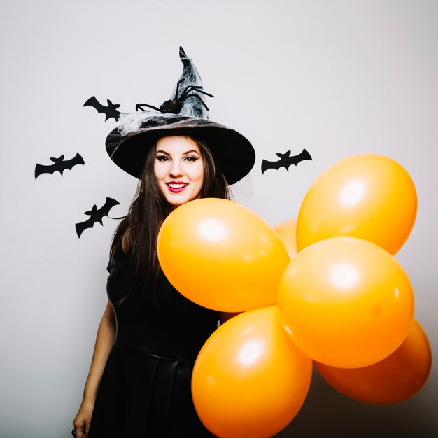 Joven atractiva mujer con globos para Halloween