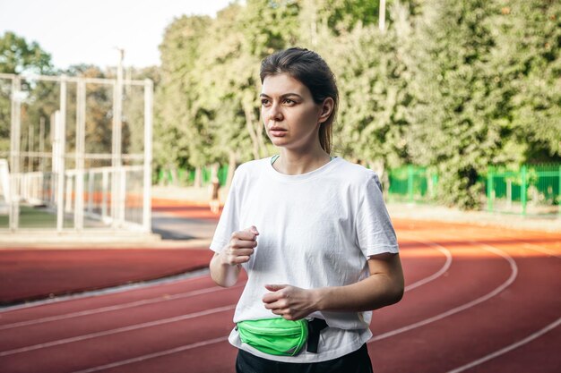 Foto gratuita una joven atractiva con ropa deportiva corriendo en el estadio.