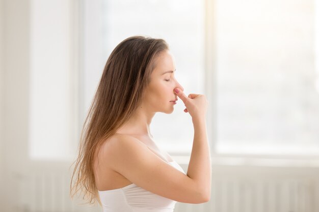 Joven, atractivo, mujer, fabricación, alternativo, nostril, respiración, blanco