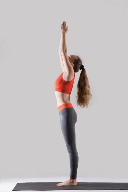 Joven, atractivo, mujer, posición, Tadasana, pose, gris, estudio, ba