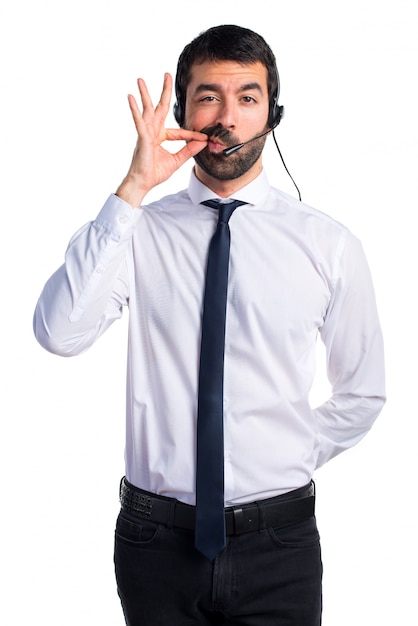 Joven con un auricular haciendo gesto de silencio