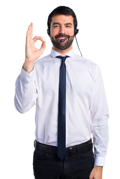 Joven con un auricular haciendo signo de OK