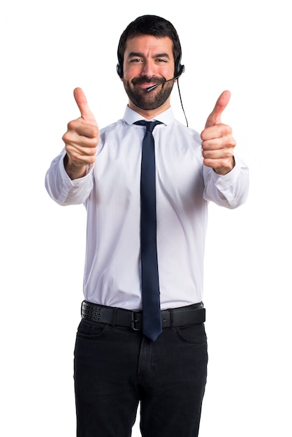 Foto gratuita joven con un auricular con el pulgar hacia arriba