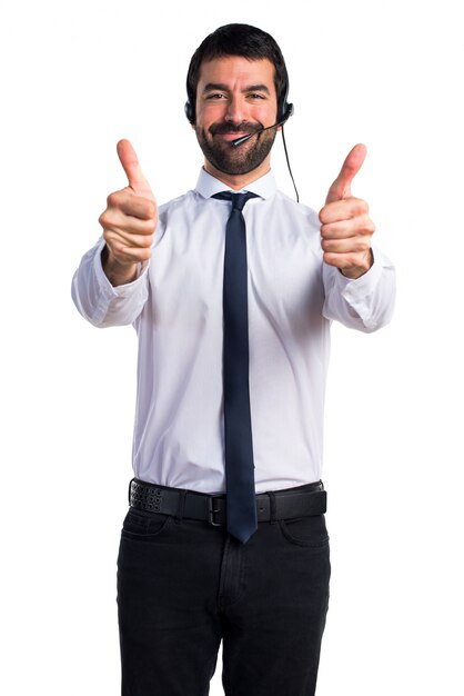 Joven con un auricular con el pulgar hacia arriba