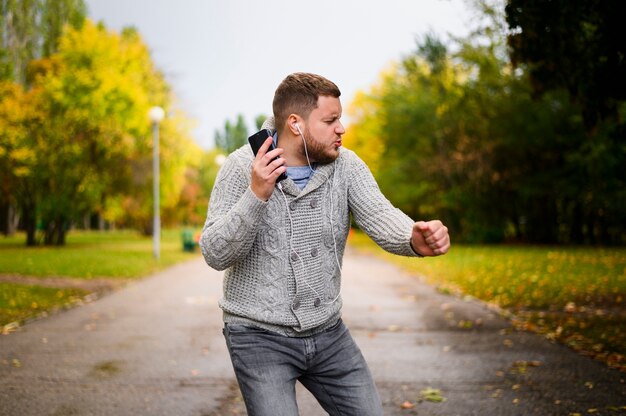 Joven con auriculares bailando en un callejón en el parque