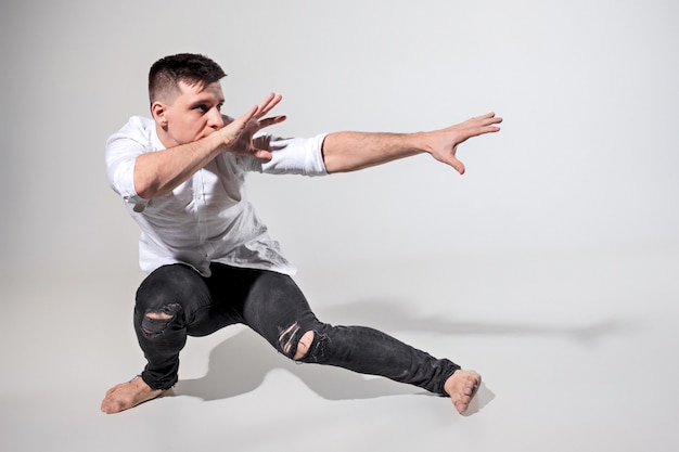 Foto gratuita el joven bailando en gris