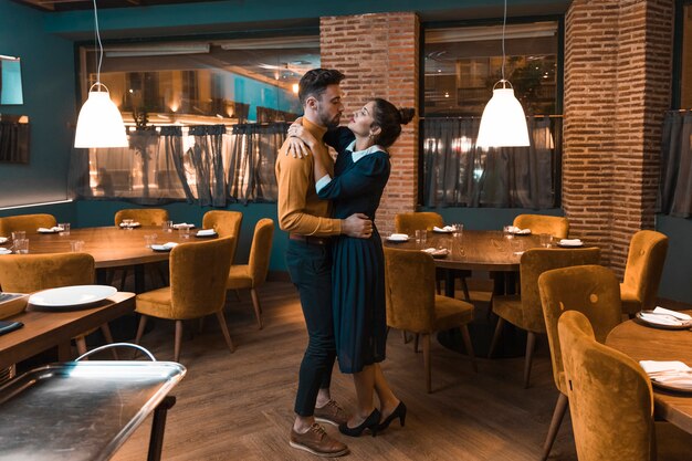 Joven bailando con mujer en restaurante