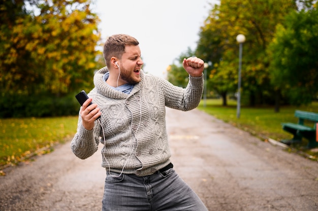 Joven bailando otoño en el parque