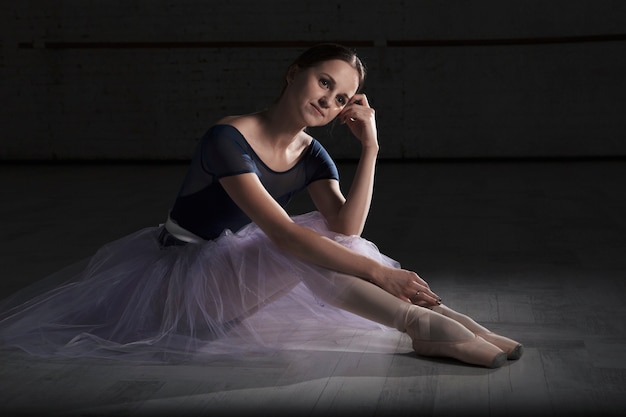 Foto gratuita joven bailarín de ballet relajante en el piso