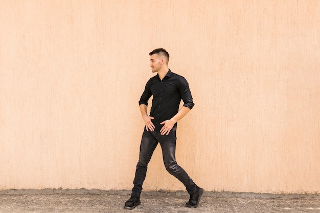 Joven bailarín callejero bailando contra la pared